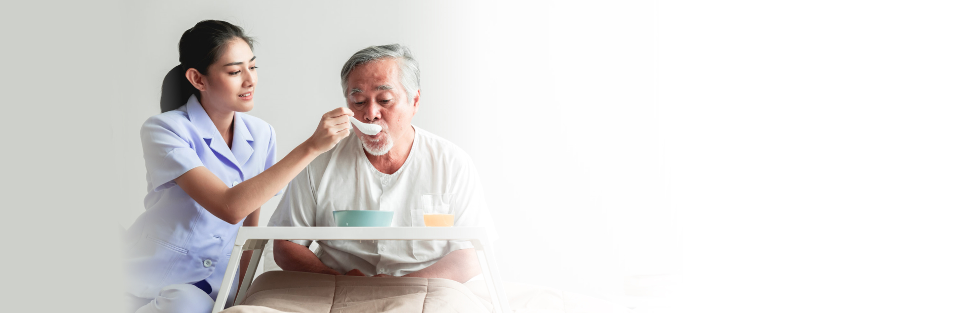 caregiver assisting senior man in eating