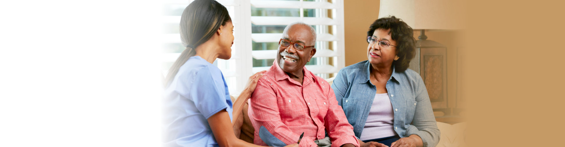 Nurse Making Notes During Home Visit With Senior Couple